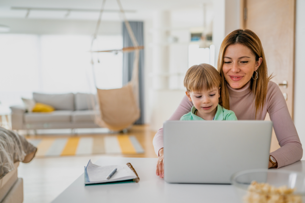 Mother and son using a laptop together, engaged in learning or entertainment
